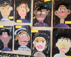 Kindergarten artwork of self-portraits made of construction page, yarn, paper, and glitter glue.