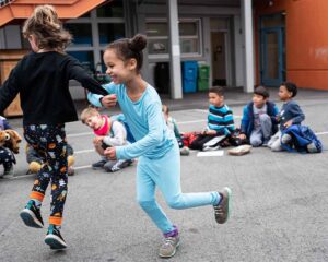 Kids run and play in the school yard.