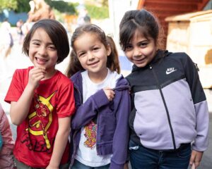 Three kindergarten students smiling.