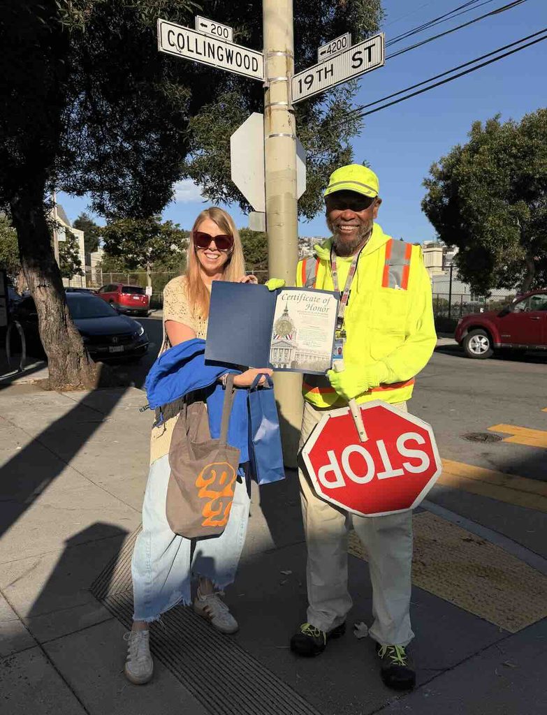 Mr. Fundi is presented a Certificate of Honor from the city of San Francisco in front of Collingwood and 19th Streets.